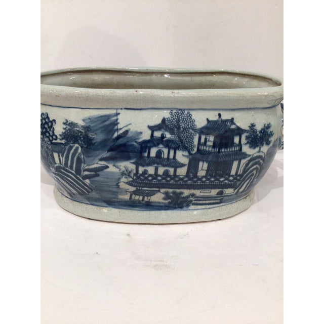 This is a beautiful blue and white vintage foot bath featuring a chinoiserie motif and twisted handles on each end