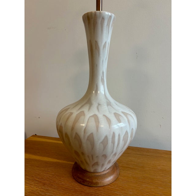 Beautiful neutral mid century glazed ceramic lamp with a walnut base. Lots of potential room options for this handsome...