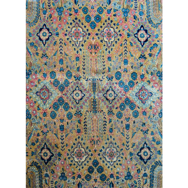 An early 20th century Persian Sarouk rug with a mirrored floral pattern containing myriad willow and cypress trees,...