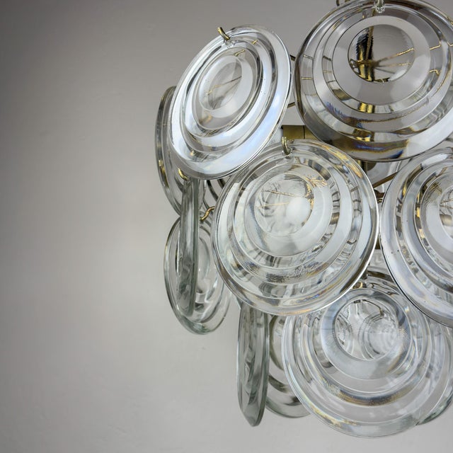 Amazing mid-century disc chandelier made in italy in the 1970s. three-tier metal base and 21 glass disc. There is one...