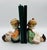 This is a pair of vintage Porcelain bookends featuring a young boy and girl engrossed in their books. These mid-century...