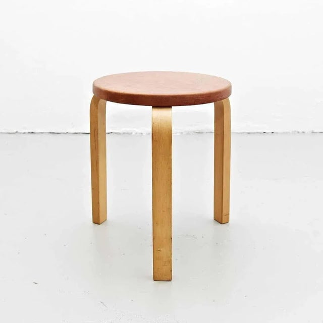 Stool designed by Alvar Aalto from 1960. Manufactured by Artek (Finland). It features new leather top, wood legs and...