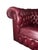 Classic English Chesterfield armchair upholstered in burgundy leather, featuring deep diamond button tufting, rolled arms,...
