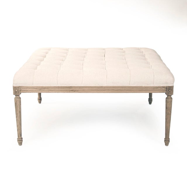 Elevate your living space with the refined elegance of this tufted cotton ottoman. Crafted with a solid natural oak frame...