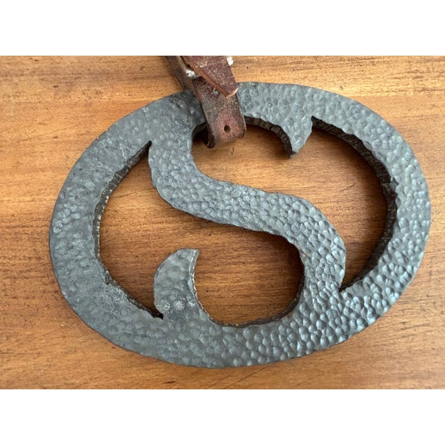 A heavy Southwestern ranch symbol "S" with an aged leather strap. A fun hand-forged detail for a Sam or Santana. Please...