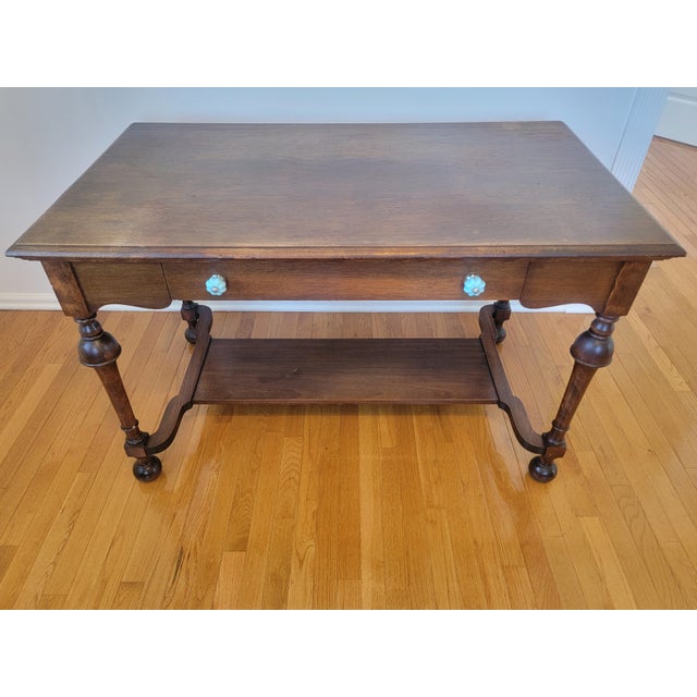 A handsome early twentieth-century American Colonial Revival writing desk crafted in solid walnut (or walnut-finished...