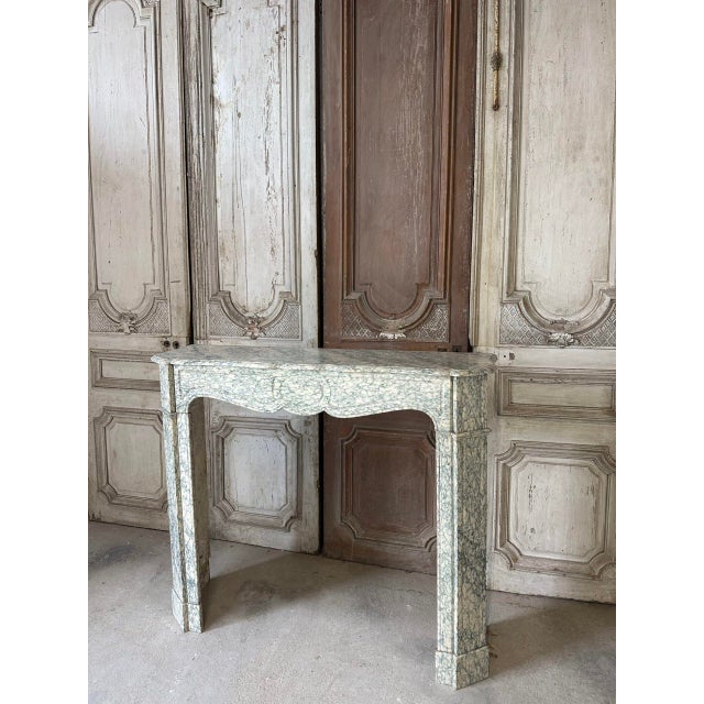 A louis xv style flat fireplace in green estours marble, circa 1900. The lintel and jambs feature recessed moldings. The...