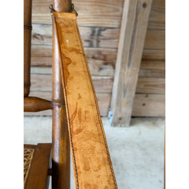 A striking pair of mid-20th century English campaign-style folding armchairs, beautifully crafted in faux bamboo with...