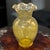 This vintage amber yellow hand-blown glass vase stands at 10.5 inches tall with a ruffled rim, adding a unique and...