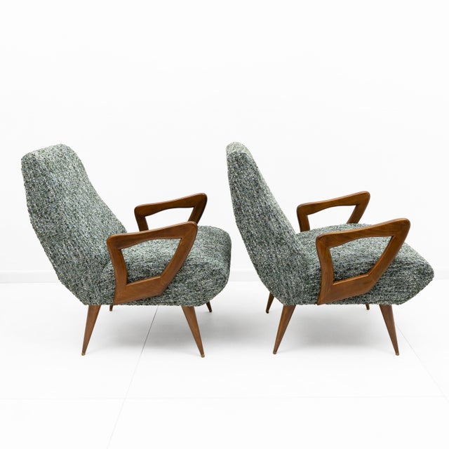 Elegant pair of Italian mid-century modern armchairs, distinguished by their generous, enveloping silhouettes and finely...