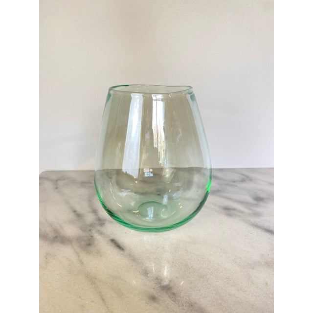 Hand-blown glass vase in a soft, pale turquoise-green hue with a gently tapered, teardrop silhouette — wider at the...