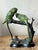 Capture the serene beauty of the aviary with this enchanting vintage bronze sculpture of two parakeets perched upon a...
