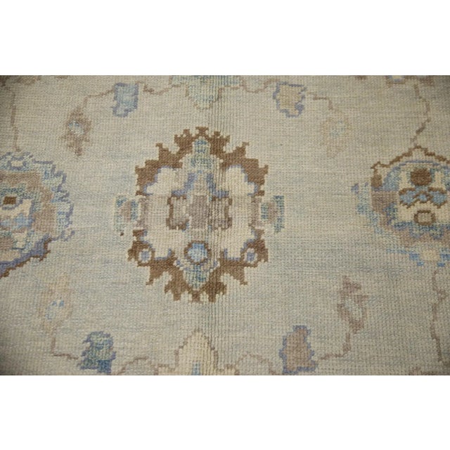 This modern Turkish Oushak rug is a stunning piece of art that has been handwoven using traditional techniques by skilled...