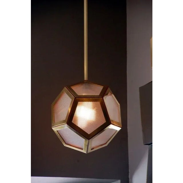 The geometric brass, tan leather and glass 'Pentagone' lantern by Design Frères. In the style of Adolf Loos. The...