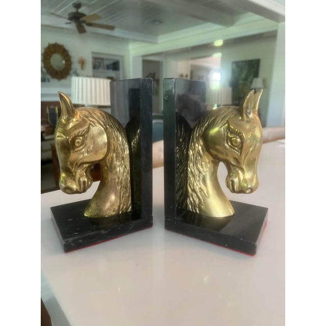 Handsome pair of brass and marble bookends with highly detailed horse head figures mounted on black marble bases. This is...