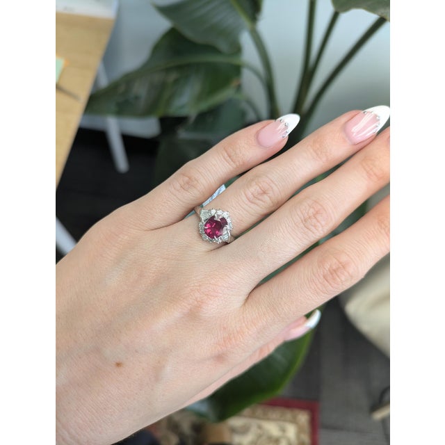 Bold and romantic, this 1.5ct Rubellite Garnet ring features a vibrant 8.4x7mm gemstone accented with natural diamonds for...