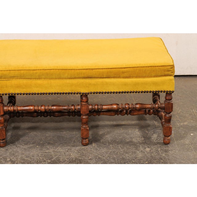 A French carved-wood and upholstered bench from the mid 20th century. This mid-century backless sofa bench from Italy is...