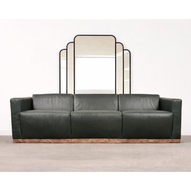 A bold and rare 1990s Dakota Jackson "Cuba" sofa finished in tailored green leather upholstery and a dramatic bronze base....