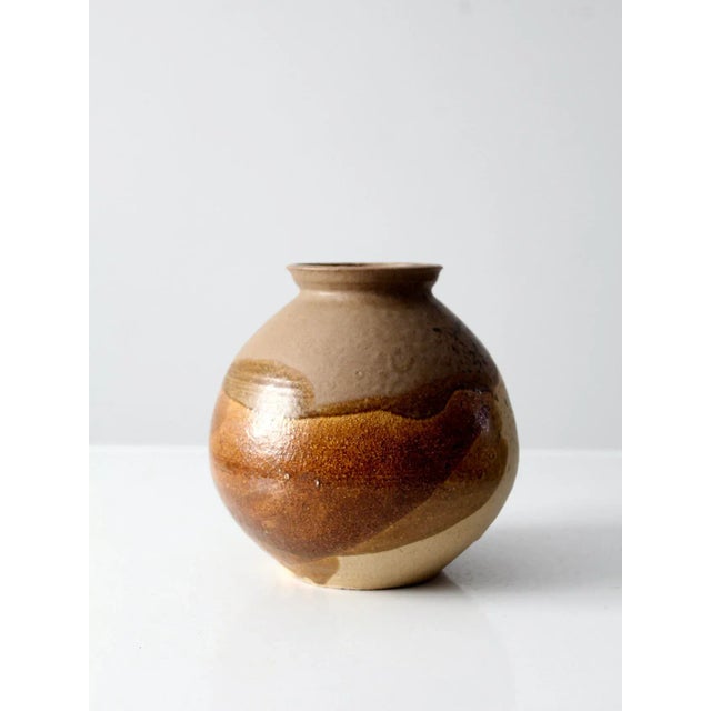 A vintage studio pottery vase, signed by the artist, crafted from substantial ceramic with a reassuringly solid presence....