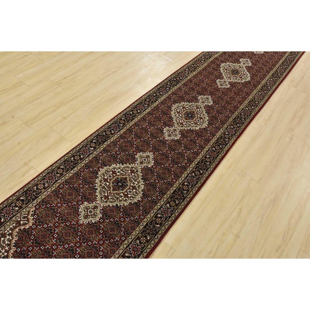 A traditional Tabriz Mahi runner hand-knotted with fine wool on a cotton foundation. This oriental rug features a row of...