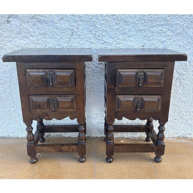 Pair of Spanish rustic-style wooden nightstands dating to the mid-20th century. Each piece features two drawers with...