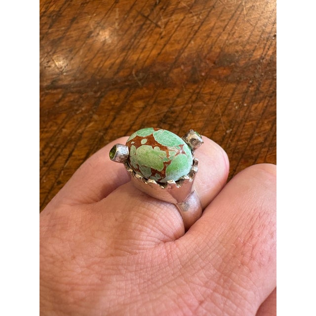 Wonderful turquoise set in a crown shaped sterling silver setting featuring two peridot gemstones