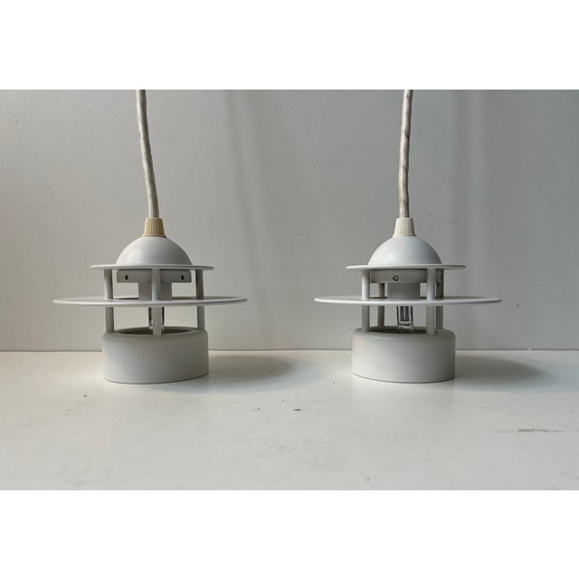 A set of small white pendant lights suitable for kitchen or hallway lighting . They are called 'planet of albertslund' or...
