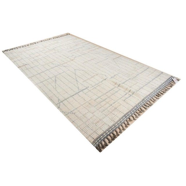 This hand knotted pile rug features a primary color palette of ivory, beige, and cream white. Crafted from wool in the...