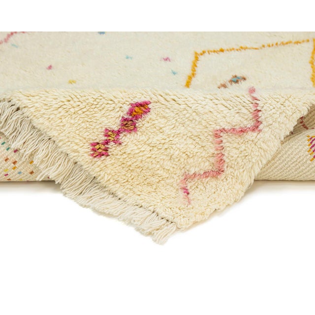 Playful zigzag borders frame a whimsical scatter of tiny diamonds, dots, and beaded pillars across a soft cream field,...
