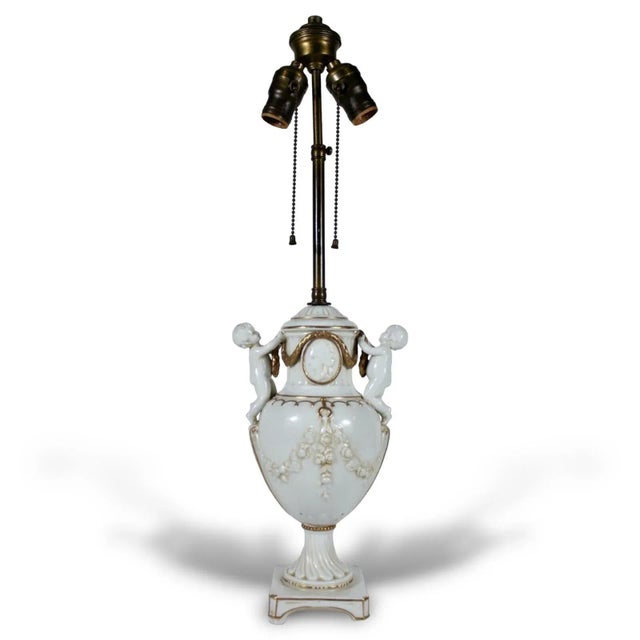 An antique french style table lamp. Porcelain with gilded accents. The lamp is marked "Germany" with a serial number and...