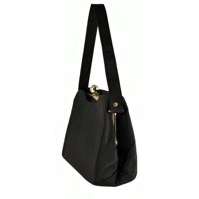 This little purse is made from a heavy black acetate fabric. It is roomy and lovely, lightweight and yet feels sturdy. The...