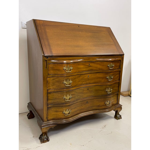 Carved in the Georgian manner about 1940, a mahogany secretary desk has secret compartments and cubicles inside.The...