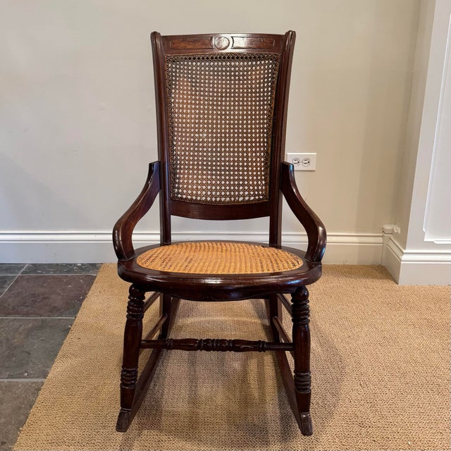 Elegant Victorian style parlor rocking chair, made of mahogany with a hand caned seat and backrest. It boasts curved...