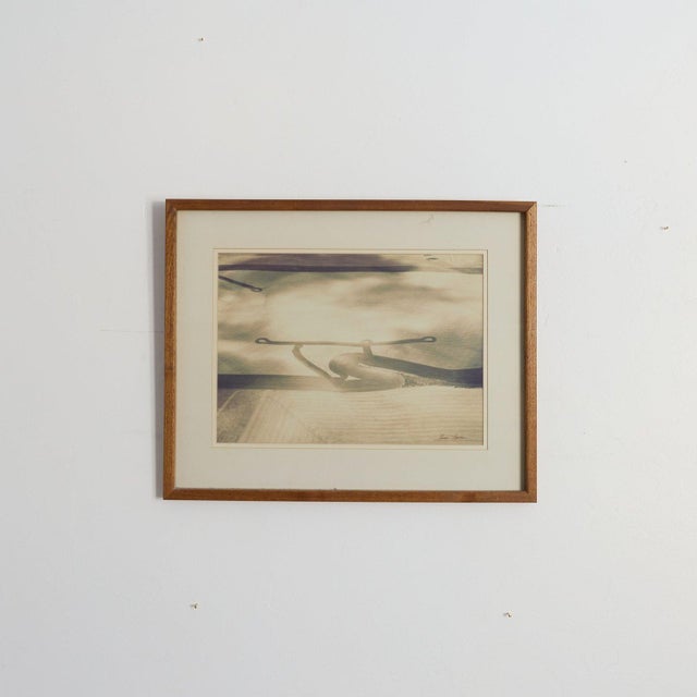 Signed original watercolor by Karen Larson in muted sepia, gray, and blue tones featuring a curved iron loop form over...