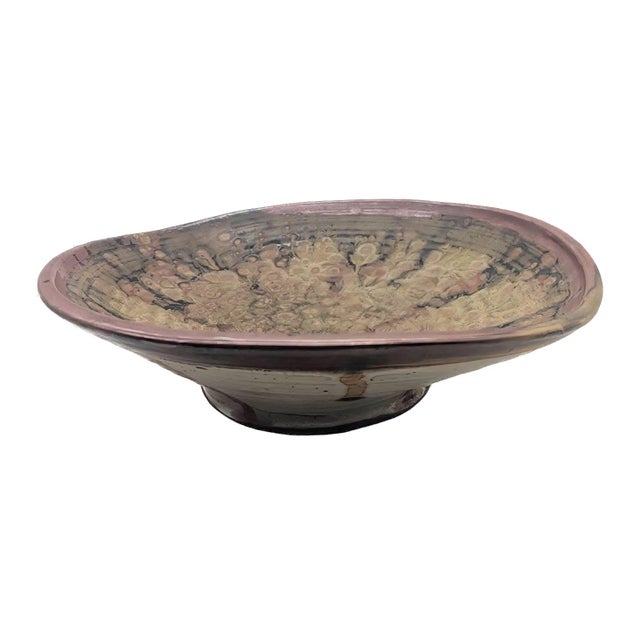 Offered is a large wheel-spun and wood-fired decorative glazed stoneware footed bowl featuring an abstract, crater-like...