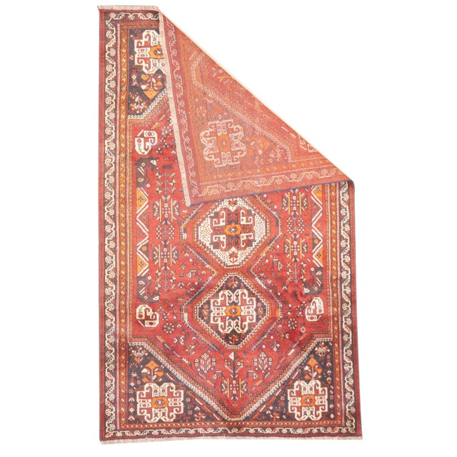 Hand-knotted Persian Qashqai rug, semi-antique. Woven in wool. The rug has three diamond-shaped medallions aligned...