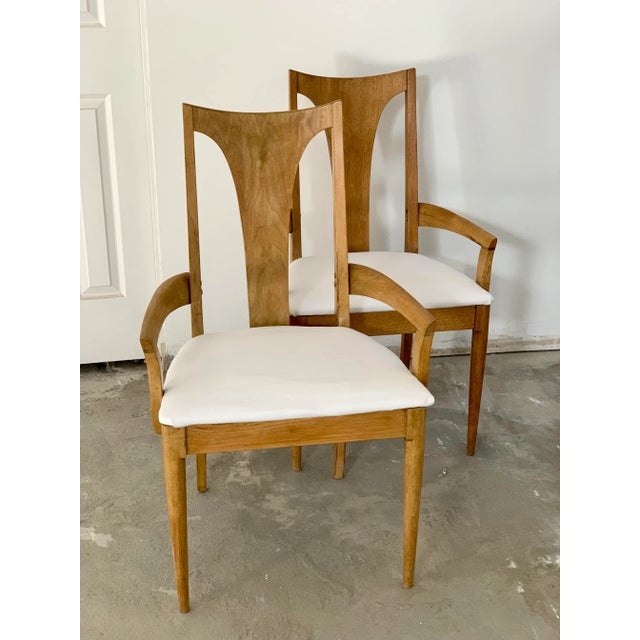 Broyhill Brasilia, a set of mid-century modern captain chairs upholstered in a white linen. A pair of vintage captain...