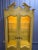 Tall vintage French Provincial style display cabinet featuring a light painted finish, decorative shaped crown, glass...