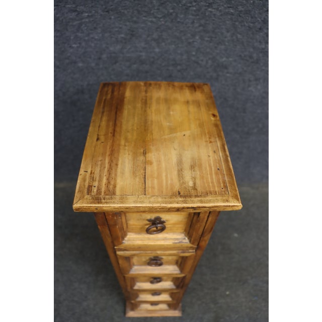 Southwestern-style tall chest of drawers crafted from solid pine, with a warm honey-toned finish and substantial paneled...