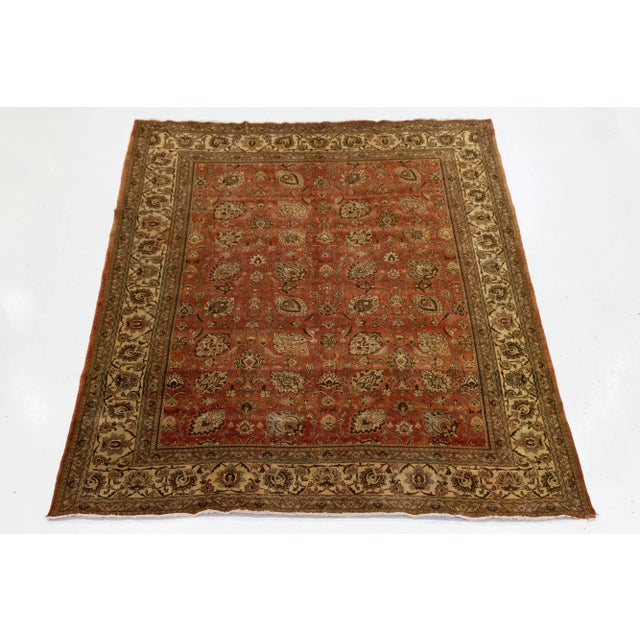 Beautiful antique Tabriz hand-knotted wool rug with a Burnt orange field. This piece features a designed frame with beige...