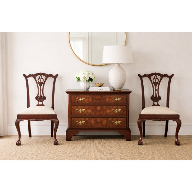 A refined set of eight Chippendale-style mahogany dining chairs featuring finely carved pierced splats, scrolling crest...