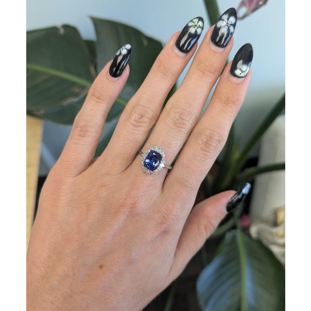 A 2.45-carat cushion tanzanite glows in rich violet-blue at the heart of this solid two-tone 14K white and rose gold ring,...