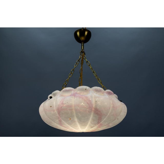 An Art Deco style marbled white and light pink glass and brass pendant light from the 1930s, Germany. This adorable...