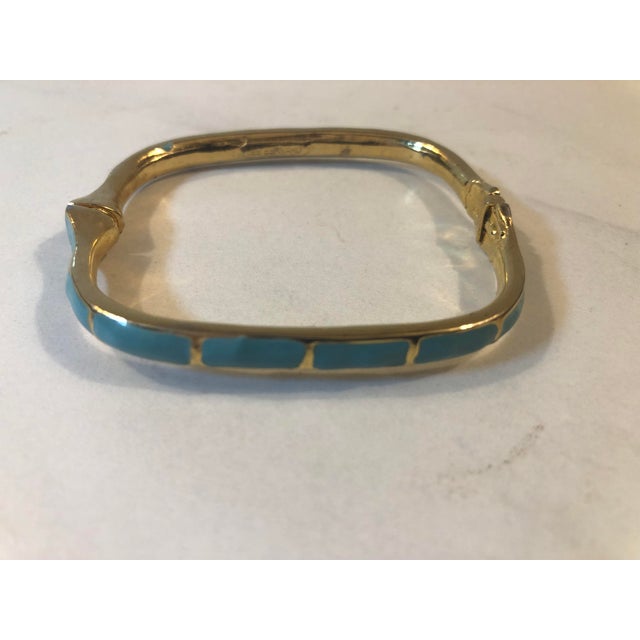 This fabulous 1970s Les Bernard Rectangular Gold Tone Turquoise Enamel Bangle will be a great addition to your vintage...