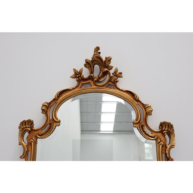 This Belgian mirror from around 1950 captures the opulent spirit of the Baroque and Louis XV traditions, reinterpreted...