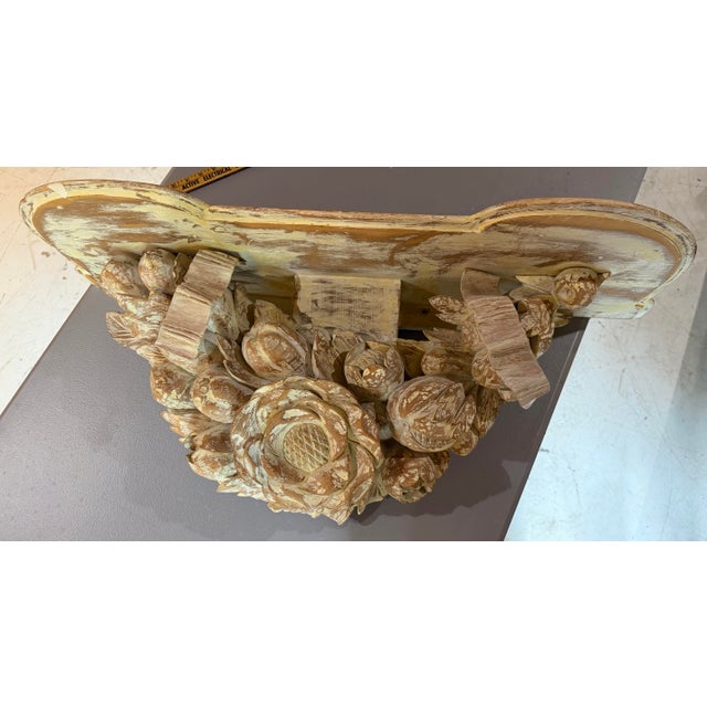 Substantial hand-carved wooden wall shelf featuring an exuberant floral and foliate motif with oversized carved blossoms,...