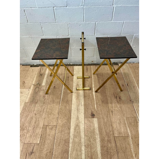 Set of 2 folding snack tray tables in a richly finished faux tortoise or oil drip finish. Shiny brass toned metal flat bar...