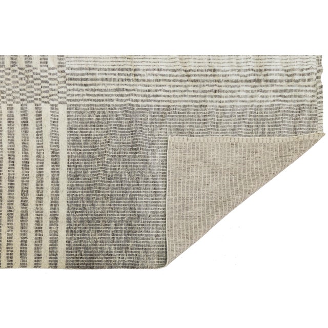 Elevate your space with this sophisticated Modern Geometric Wool Rug, featuring an intricate, hand-woven grid design....