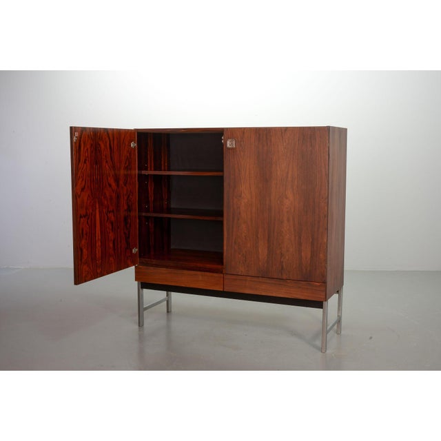 This beautiful high quality finished midcentury Dutch design rosewood cabinet is attributed to the German designer Rudolf...