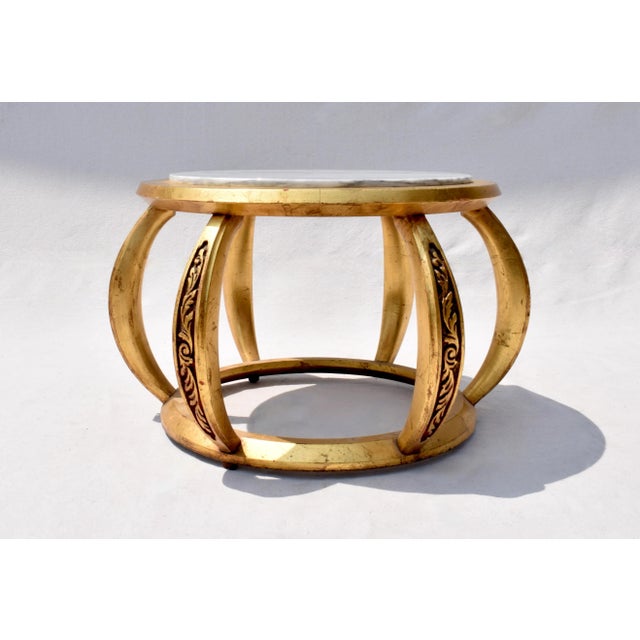 An unusual pair of mid 20th century round gold giltwood open tables with marble tops made in Italy; signed. Hollywood...